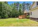 Home's spacious backyard features a large deck and an enclosed porch, surrounded by lush trees and a green lawn at 123 Holiday Island Dr, Garner, NC 27529