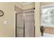 Bathroom featuring a shower stall and soaking tub, enhanced by a decorative window and natural light at 123 Holiday Island Dr, Garner, NC 27529