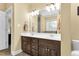 Dual sink vanity bathroom with dark wood cabinetry, granite counters, and a well-lit mirror and tile backsplash at 123 Holiday Island Dr, Garner, NC 27529