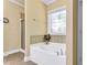 Relaxing bathroom with a large tub featuring tile accents and an elegant stained glass window for natural light at 123 Holiday Island Dr, Garner, NC 27529