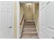 Carpeted staircase with a wooden handrail and white trim, connecting different levels of the home at 123 Holiday Island Dr, Garner, NC 27529