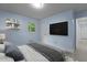 Bright bedroom with modern minimalist style, featuring a sleek TV and two windows at 1302 Buffaloe Rd, Garner, NC 27529