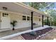 Inviting front porch with a swing, charming brick accents, and a well-manicured landscape for a relaxing outdoor space at 1302 Buffaloe Rd, Garner, NC 27529