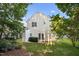 Two-story home showcasing a spacious backyard with well-maintained grass and surrounded by mature trees at 131 Cricketgrass Dr, Cary, NC 27513