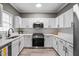 Well-lit kitchen featuring stainless steel appliances, white cabinets, and modern fixtures at 131 Cricketgrass Dr, Cary, NC 27513