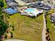 An aerial view shows a community clubhouse with a pool, tennis court, and ample green space and walking paths at 131 English Violet Ln, Raleigh, NC 27610