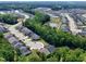 An aerial view reveals a neighborhood nestled in nature, featuring community ponds, a pool, and tree-lined streets at 131 English Violet Ln, Raleigh, NC 27610