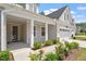 Covered front porch featuring white columns and beautifully landscaped garden at 131 English Violet Ln, Raleigh, NC 27610