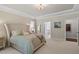 Spacious main bedroom with a tray ceiling, decorative chandelier, and neutral color palette at 131 English Violet Ln, Raleigh, NC 27610
