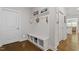 Inviting mudroom with built-in bench, storage cubbies, coat hooks, and warm hardwood floors at 131 English Violet Ln, Raleigh, NC 27610