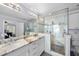 Well-lit bathroom with dual vanities, granite countertops, and a luxurious glass shower at 1401 Granada Dr, Raleigh, NC 27612