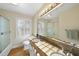 Well-lit bathroom features a double vanity, large mirror, and shower with glass door at 1401 Granada Dr, Raleigh, NC 27612