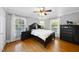 Charming bedroom with hardwood floors, a ceiling fan, and sunny windows at 1401 Granada Dr, Raleigh, NC 27612