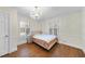 Bright bedroom featuring a chandelier, hardwood floors, and natural light from windows at 1401 Granada Dr, Raleigh, NC 27612