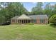Well-manicured front lawn showcasing this charming brick home with covered entry at 1401 Granada Dr, Raleigh, NC 27612