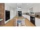Bright kitchen features a brick island with granite countertop, stainless steel appliances, and white cabinetry at 1401 Granada Dr, Raleigh, NC 27612