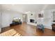 Open living room with hardwood floors and a painted brick fireplace, perfect for entertaining and relaxing at 1401 Granada Dr, Raleigh, NC 27612