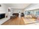 Comfortable living room boasts hardwood floors, fireplace, and bright sunroom views, offering a cozy retreat at 1401 Granada Dr, Raleigh, NC 27612