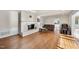 Inviting living room featuring a white brick fireplace, hardwood floors, and access to other rooms at 1401 Granada Dr, Raleigh, NC 27612