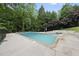 Inviting in-ground pool surrounded by mature trees and greenery for privacy at 1401 Granada Dr, Raleigh, NC 27612