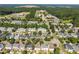 Wide aerial showcases neighborhood, surrounding greenery, and nearby buildings at 148 Danesway Dr, Holly Springs, NC 27540