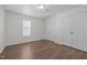 Neutral bedroom with a window, wood-look floors, and ample closet space for storage at 148 Danesway Dr, Holly Springs, NC 27540