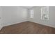 Neutral bedroom has two windows, and wood floor at 148 Danesway Dr, Holly Springs, NC 27540