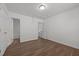 A clean bedroom with wood-look floors offering convenient access to a bathroom and closet at 148 Danesway Dr, Holly Springs, NC 27540