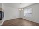Bright dining room features modern chandelier, wood floors and natural light from the large windows at 148 Danesway Dr, Holly Springs, NC 27540