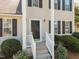 Inviting front porch with classic columns, dark door, and tidy landscaping creates curb appeal at 148 Danesway Dr, Holly Springs, NC 27540