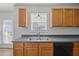 Kitchen features wood cabinets, double sink, and lots of natural light from window above sink at 148 Danesway Dr, Holly Springs, NC 27540
