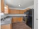 Kitchen features wood cabinets, black appliances, stainless sink and ample counter space at 148 Danesway Dr, Holly Springs, NC 27540