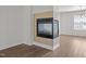 Modern fireplace with tile surround, hardwood floors, and a window, adding natural light to the living space at 148 Danesway Dr, Holly Springs, NC 27540