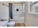 Updated bathroom with white marble-style tile surround and modern fixtures at 1592 Boone Rd, Elon, NC 27244