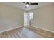 Bedroom features wood-look floors, neutral paint, a ceiling fan, and a window overlooking outside at 1592 Boone Rd, Elon, NC 27244