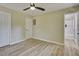 Bedroom boasts wood-look floors, neutral paint, a ceiling fan, a closet, and an ensuite bath at 1592 Boone Rd, Elon, NC 27244