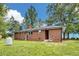 Back exterior of brick home with an expansive yard and trees at 1592 Boone Rd, Elon, NC 27244