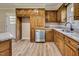 This kitchen has wood cabinets, stainless steel appliances, granite countertops, and wood-look flooring at 1592 Boone Rd, Elon, NC 27244