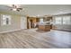 Open concept kitchen and living area with hardwood floors, island, cabinets and stone fireplace at 1592 Boone Rd, Elon, NC 27244