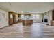 Open concept kitchen and living area with hardwood floors, island, cabinets and stone fireplace at 1592 Boone Rd, Elon, NC 27244