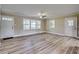 Bright living room featuring beautiful flooring, a ceiling fan, and large windows for natural light at 1592 Boone Rd, Elon, NC 27244