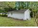Picture of a white storage shed or outbuilding with a door and windows, surrounded by lush greenery and mature trees at 1592 Boone Rd, Elon, NC 27244