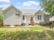 Exterior back view of a home with a patio, lawn, two blue Adirondack chairs, and hydrangeas at 1662 Beechaven Rd, Fuquay Varina, NC 27526