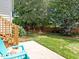 Cozy backyard featuring a patio, a blue Adirondack chair, and lush green grass at 1662 Beechaven Rd, Fuquay Varina, NC 27526