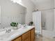 Spacious bathroom with dual sinks, wooden cabinets, and a shower-tub combination at 1662 Beechaven Rd, Fuquay Varina, NC 27526