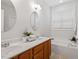 Bright bathroom featuring a soaking tub, dual sinks, and wood cabinets at 1662 Beechaven Rd, Fuquay Varina, NC 27526