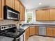 This kitchen is complete with wooden cabinetry, and stainless steel appliances at 1662 Beechaven Rd, Fuquay Varina, NC 27526