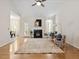 Bright living room featuring a cozy fireplace, ceiling fan, and hardwood floors at 1662 Beechaven Rd, Fuquay Varina, NC 27526