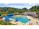 Community pool area with a slide, sun loungers, and a clubhouse, set against a lush green landscape at 1662 Beechaven Rd, Fuquay Varina, NC 27526
