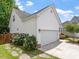 White home exterior featuring an attached garage, well-maintained lawn, and flower beds at 1662 Beechaven Rd, Fuquay Varina, NC 27526